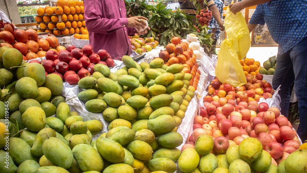 Customer using polybag to take fruits after buying from local fruit market at Mirpur, Dhaka, Bangladesh