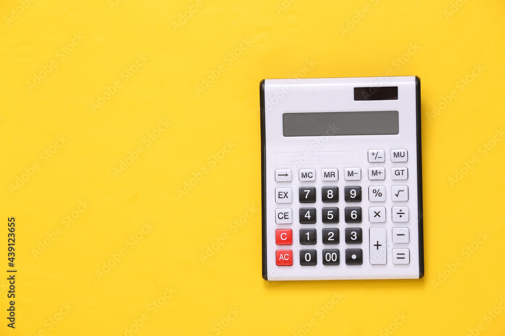 Large white calculator on yellow background Large white calculator on yellow background