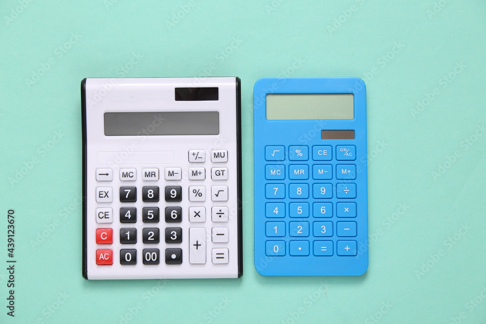 Two calculators on a blue background. Top view Two calculators on a blue background. Top view