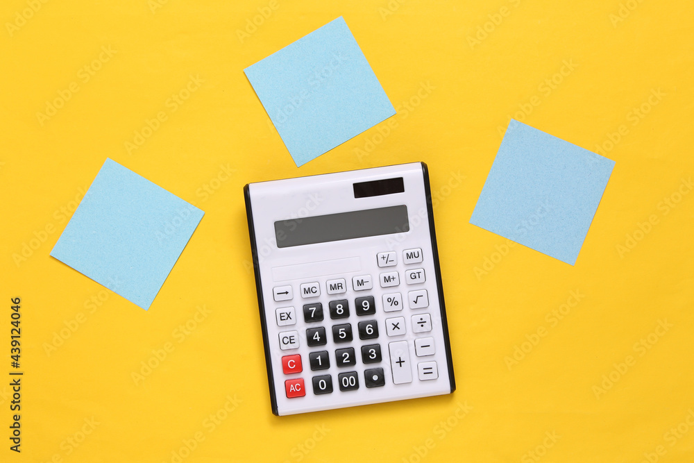 Calculator with blank memo papers on yellow background Calculator with blank memo papers on yellow background