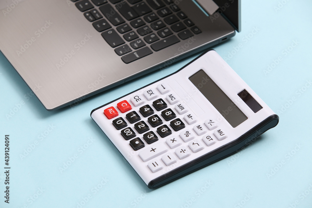 Calculator and laptop on blue background. Calculator and laptop on blue background.