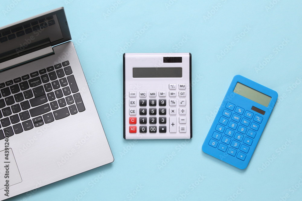 Calculators and laptop on blue background. Top view Calculators and laptop on blue background. Top view