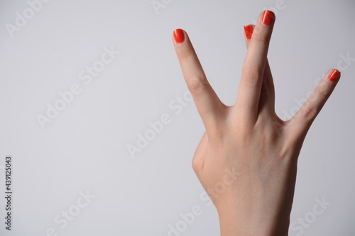 Closeup of female hand showing west side sign isolated on white background
