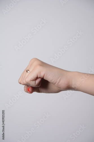 Woman raised fist, or the clenched fist, isolated on white background.