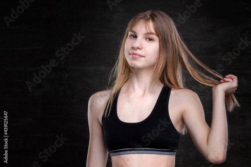 Teenage girl in a sports shirt on a dark background. © Светлана Лазаренко