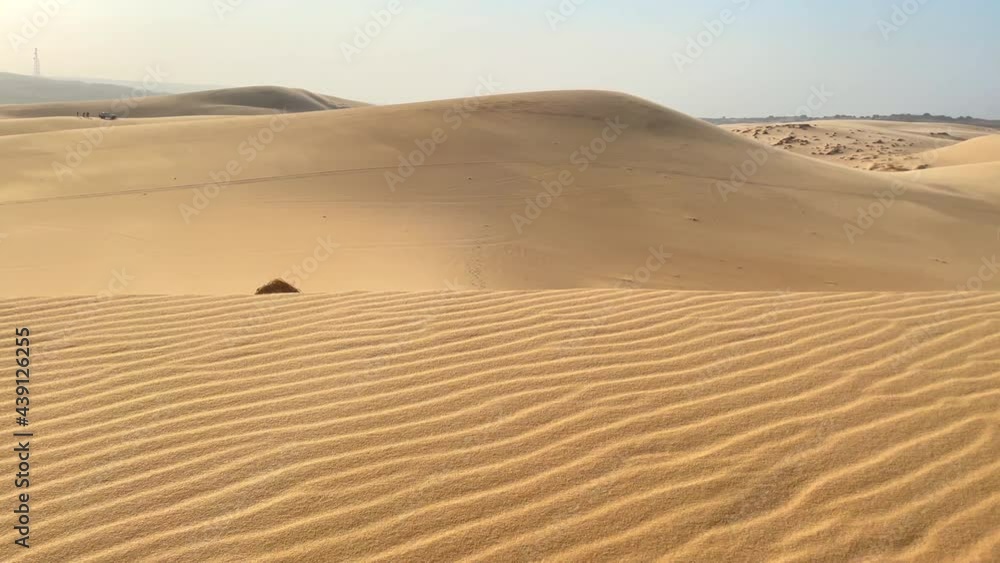 A man in an office cloth crawls up a dune in a desert. Overcoming challenges in business A man in an office cloth crawls up a dune in a desert. Overcoming challenges in business