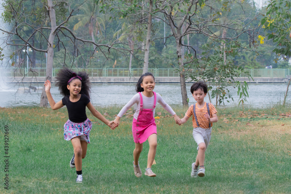 Adorable children hold hand together enjoy running in green park on holiday, group of primary school friendship play in garden, children Afro mix race girl and Asian kids spent time with nature Adorable children hold hand together enjoy running in green park on holiday, group of primary school friendship play in garden, children Afro mix race girl and Asian kids spent time with nature