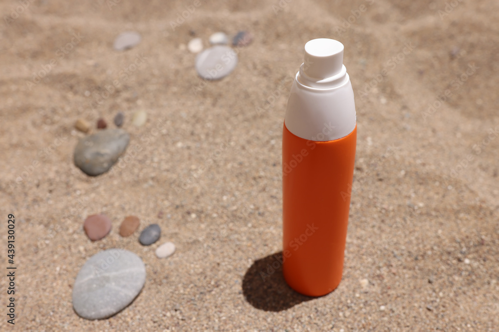 Bottle of sunscreen lotion sits on hot sand Bottle of sunscreen lotion sits on hot sand