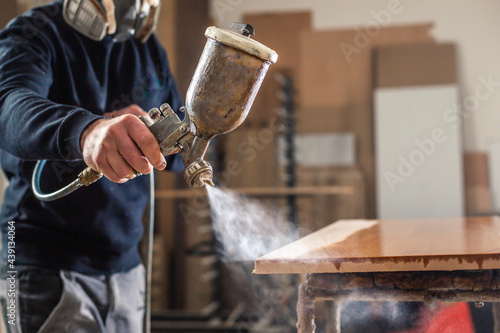 Process of varnishing or spraying wood by automatical spray in the professional joinery shop, industrial concept