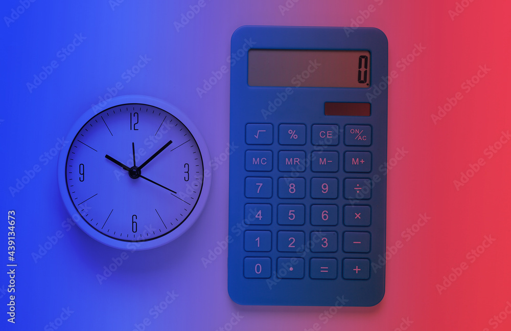 White clock and calculator in neon light. Minimalistic studio shot. Top view White clock and calculator in neon light. Minimalistic studio shot. Top view