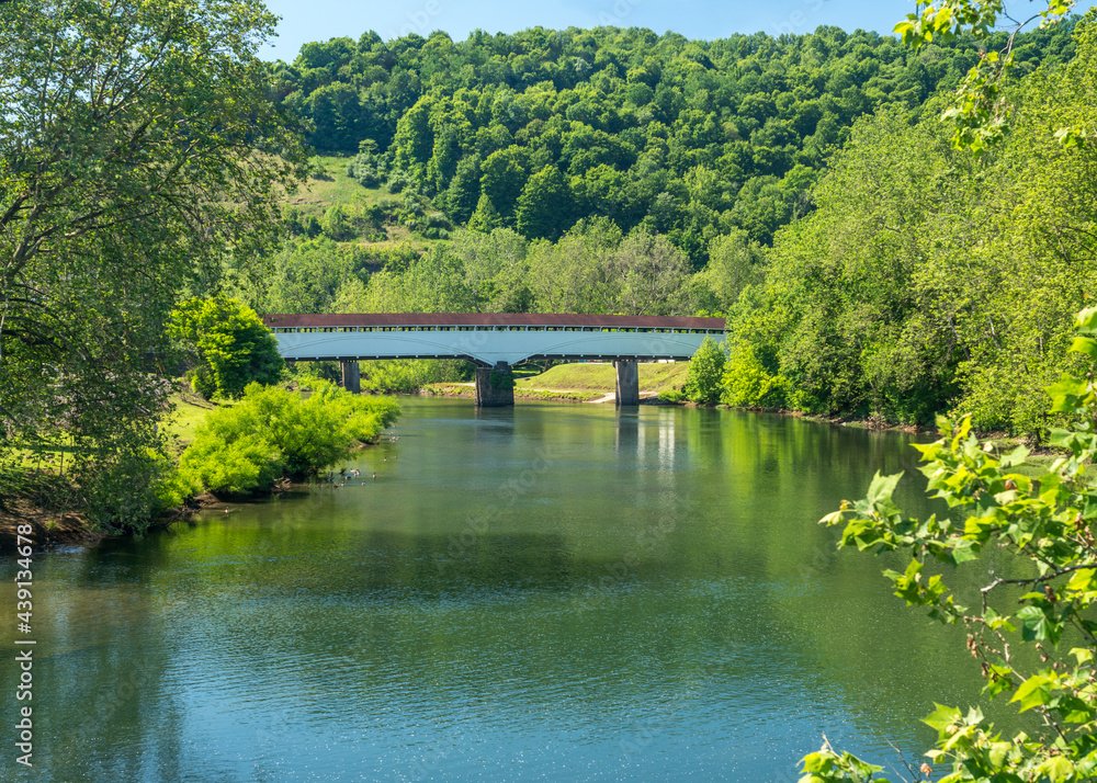 View along the Tygart river towards the historic covered bridge leading into the small town of Philippi in West Virginia View along the Tygart river towards the historic covered bridge leading into the small town of Philippi in West Virginia