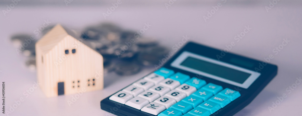 Investment about home with calculator and model house and coins on desk, property and real estate and mortgage, loan and finance, financial saving and account for residential, business concept. Investment about home with calculator and model house and coins on desk, property and real estate and mortgage, loan and finance, financial saving and account for residential, business concept.