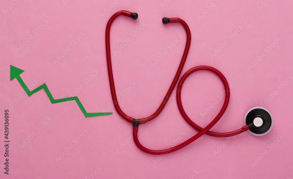 Stethoscope with growth arrow on red background. Top view Stethoscope with growth arrow on red background. Top view