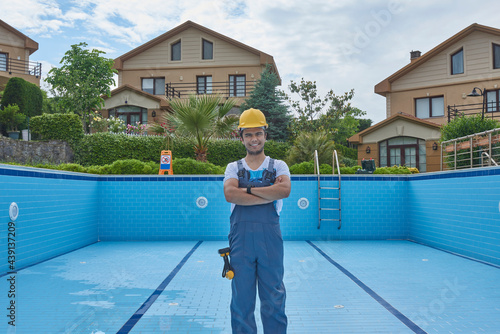 Repairman is repairing pool with equipment. Pool maintenance style. photo