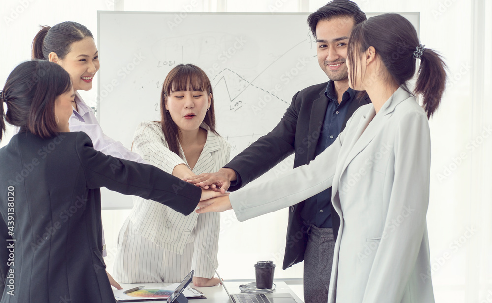 Obraz premium A team of staff members join hands in a brainstorming meeting to help each other work as a team for success. 