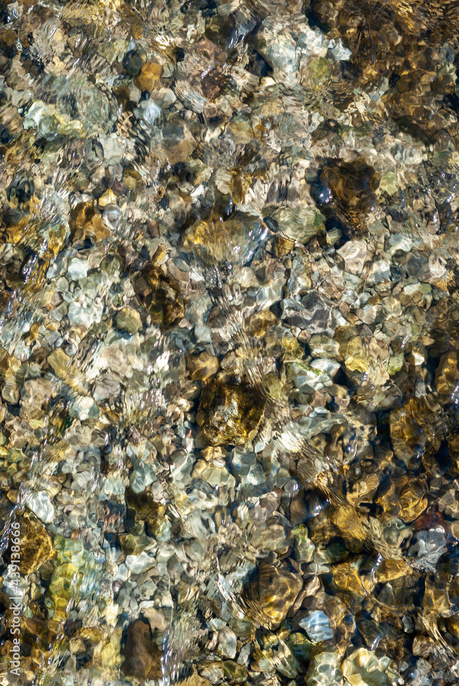 Stones under water on river bottom in sunny day Stones under water on river bottom in sunny day