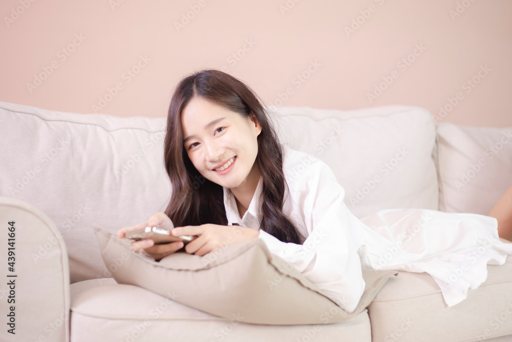 Beautiful Asian woman using mobile phone and internet technology to use online chat with her friends during stay at home Beautiful Asian woman using mobile phone and internet technology to use online chat with her friends during stay at home