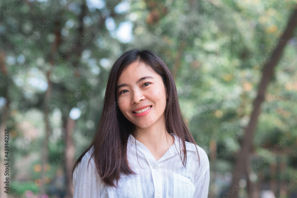 attractive adult business woman asian girl with happy and smile standing on walk way go to working between her office on morning under green forest. attractive adult business woman asian girl with happy and smile standing on walk way go to working between her office on morning under green forest.
