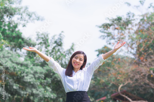attractive adult business woman asian girl with happy and smile walking and show hand up between her go to office on morning with green forest background.