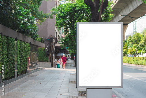 big blank billboard white LED screen vertical outstanding in the city side the road traffic for display advertisement text template promotion new brand at outdoor with green tree vintage color tone.