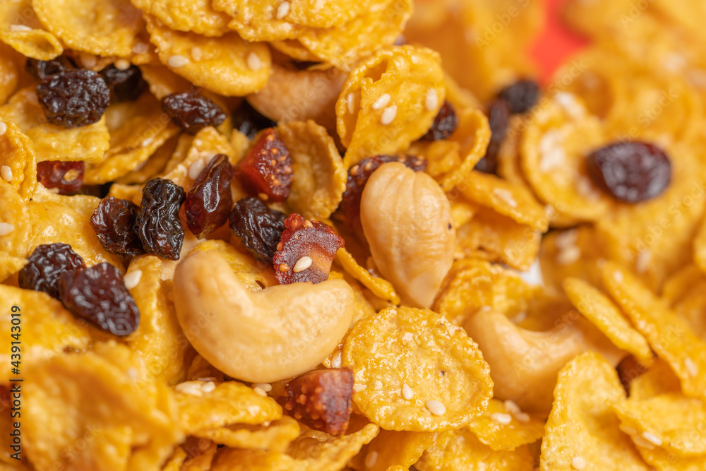 Cornflakes honey caramel homemade with grains, currant, cashew nut, dried strawberries and white sesame healthy food snack on a white plate close up and Macro copy space. Cornflakes honey caramel homemade with grains, currant, cashew nut, dried strawberries and white sesame healthy food snack on a white plate close up and Macro copy space.