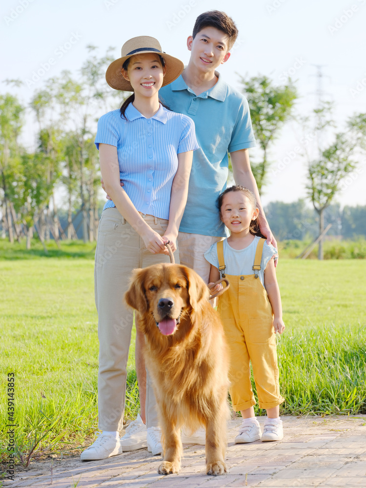 Happy family of three and pet dog in the park Happy family of three and pet dog in the park