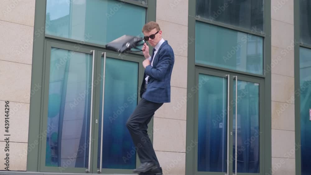 Successful joyful business man dancing near the business center or firm office Successful joyful business man dancing near the business center or firm office