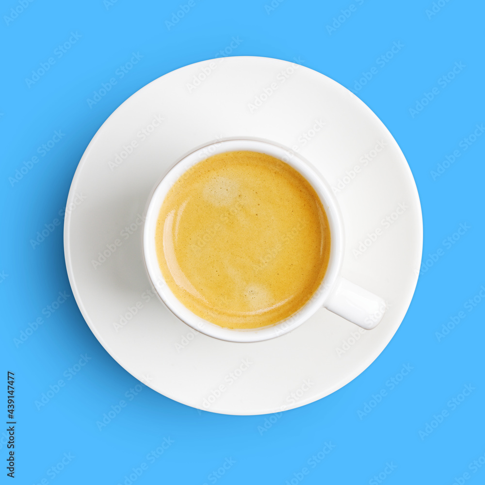 Closeup white cup of coffee espresso isolated on blue with shadow. Top view. Closeup white cup of coffee espresso isolated on blue with shadow. Top view.