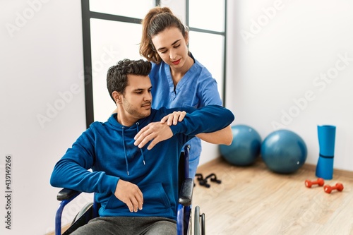 Young disabled man making mobility exercise sitting on wheelchair at the clinic.