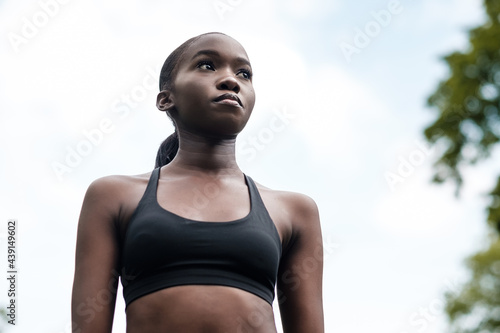 Black young woman doing exercise in a park.