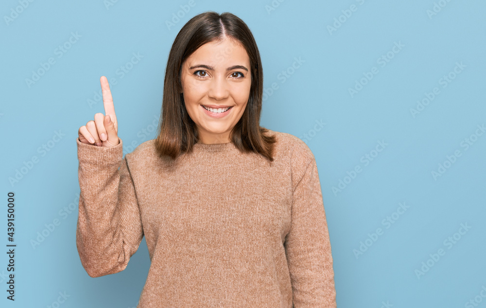 Young beautiful woman wearing casual clothes pointing finger up with successful idea. exited and happy. number one. Young beautiful woman wearing casual clothes pointing finger up with successful idea. exited and happy. number one.