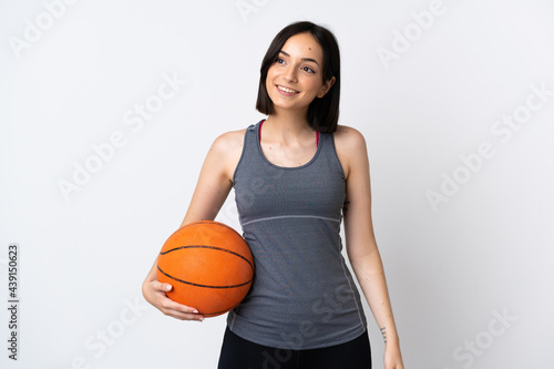 Young woman playing basketball isolated on white background thinking an idea while looking up