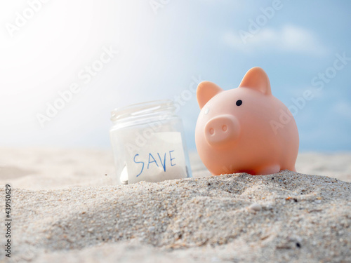 Coins collected in a glass jar are placed on the beach.Saving money wealth and financial concept.Piggy bank on the beach