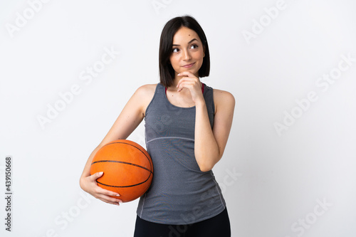 Young woman playing basketball isolated on white background and looking up