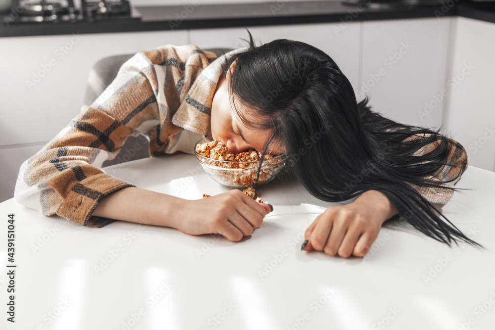 The girl fell asleep face down in a plate of popcorn. A young girl fell ...