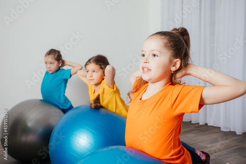 Kids doing physical exercises on large fitballs