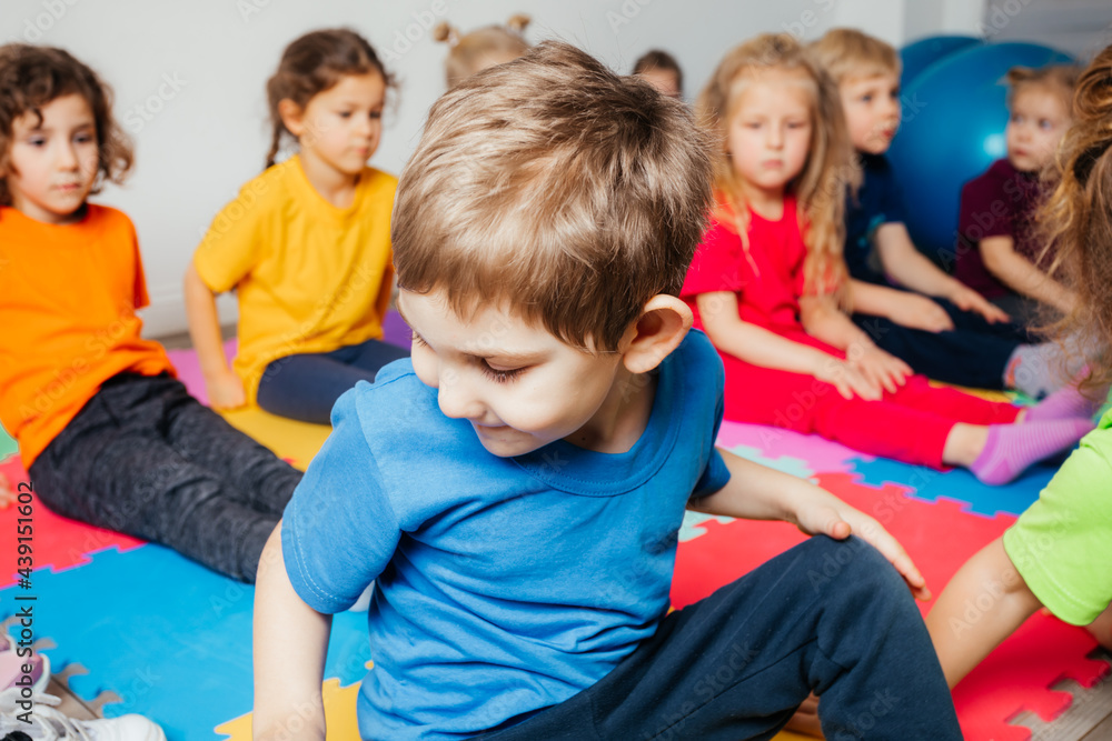 Curious preschool boy enjoying group gymnastic training Curious preschool boy enjoying group gymnastic training