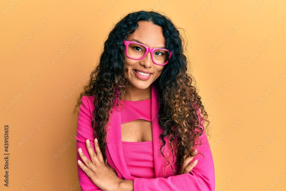 Fototapeta premium Young latin woman wearing business style and glasses happy face smiling with crossed arms looking at the camera. positive person.