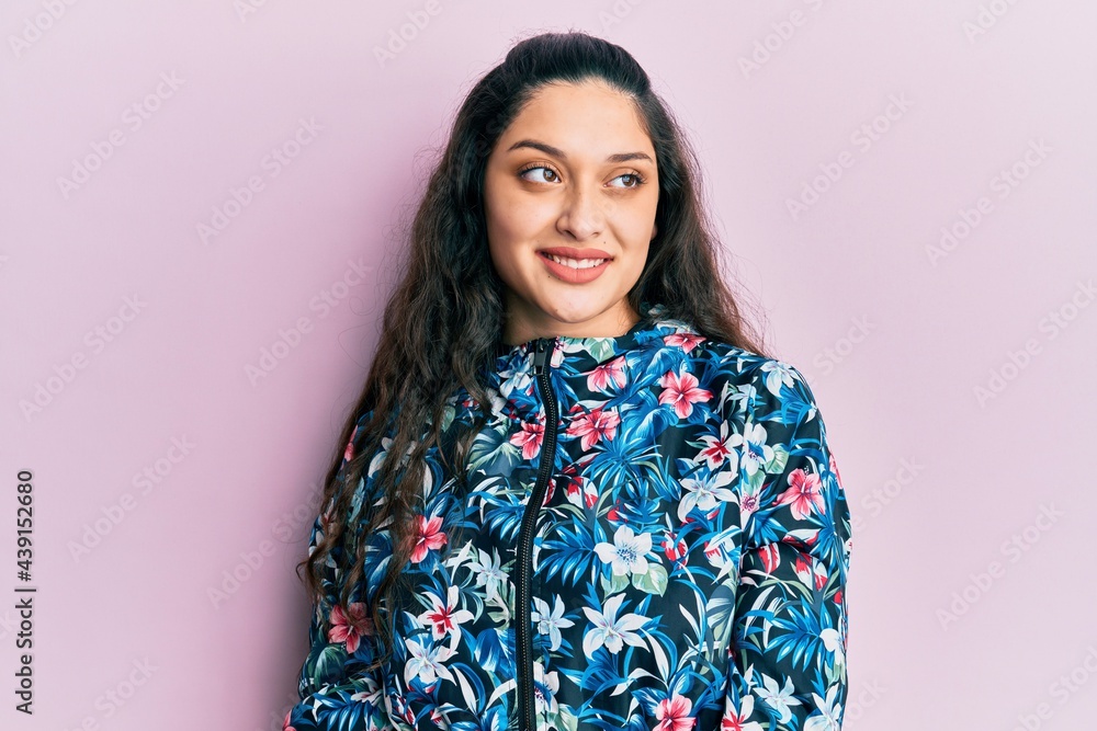 Beautiful middle eastern woman wearing casual floral jacket looking away to side with smile on face, natural expression. laughing confident. Beautiful middle eastern woman wearing casual floral jacket looking away to side with smile on face, natural expression. laughing confident.
