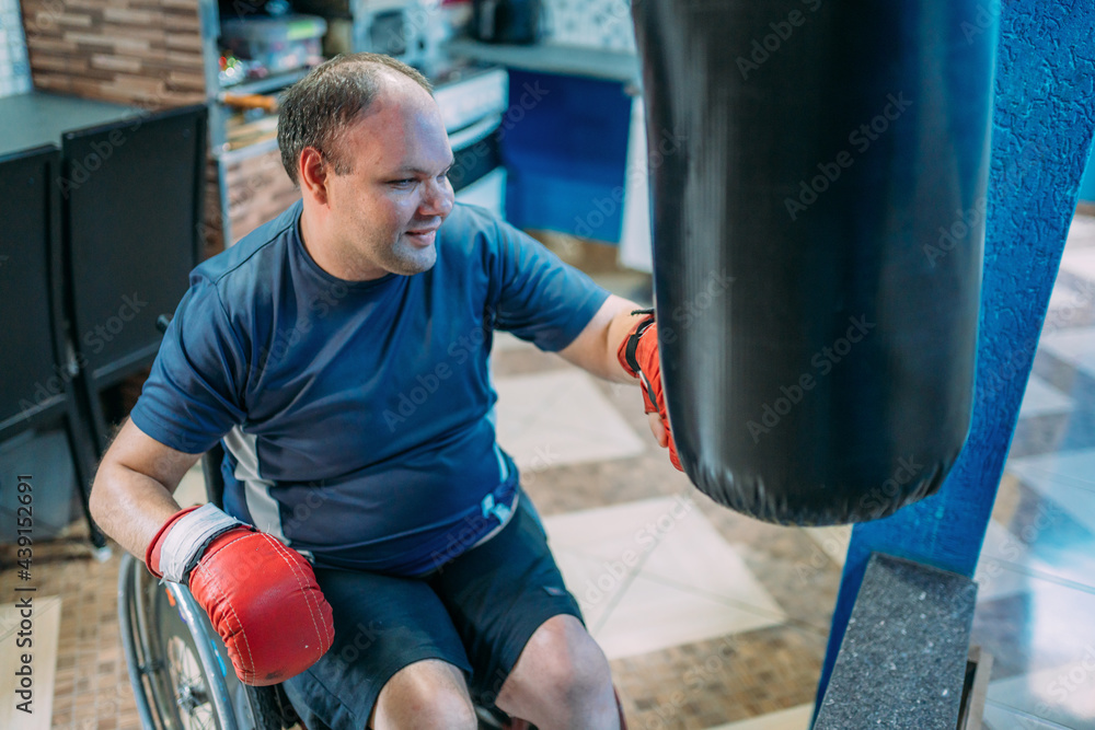 Latin disabled boxer at wheelchair doing exercises at home.