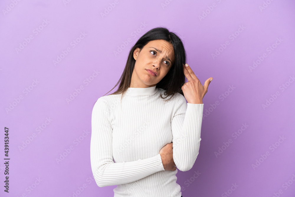 Young caucasian woman isolated on purple background with problems making suicide gesture Young caucasian woman isolated on purple background with problems making suicide gesture