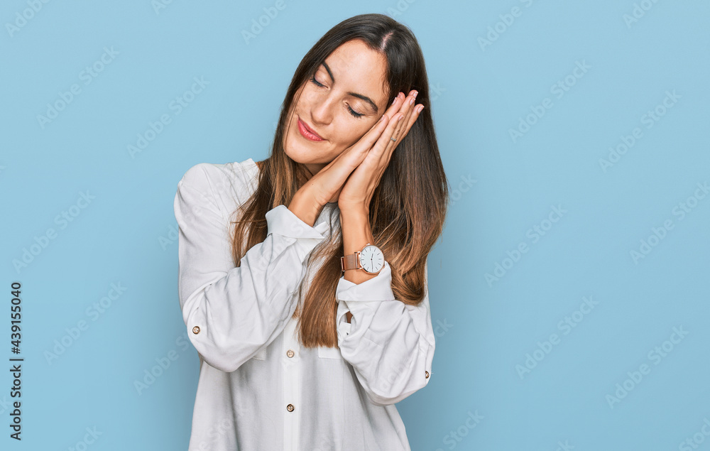 Young beautiful woman wearing casual clothes sleeping tired dreaming and posing with hands together while smiling with closed eyes. Young beautiful woman wearing casual clothes sleeping tired dreaming and posing with hands together while smiling with closed eyes.