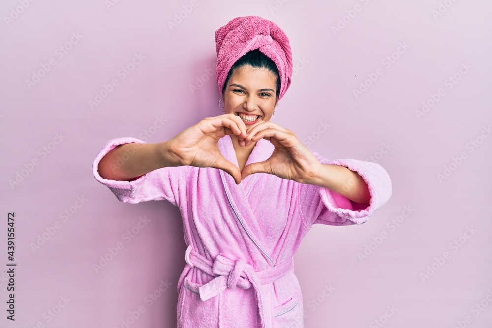 Young hispanic woman wearing shower towel cap and bathrobe smiling in love doing heart symbol shape with hands. romantic concept. Young hispanic woman wearing shower towel cap and bathrobe smiling in love doing heart symbol shape with hands. romantic concept.