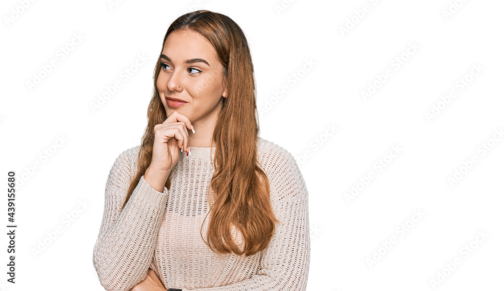 Young blonde woman wearing casual clothes with hand on chin thinking about question, pensive expression. smiling with thoughtful face. doubt concept. Young blonde woman wearing casual clothes with hand on chin thinking about question, pensive expression. smiling with thoughtful face. doubt concept.