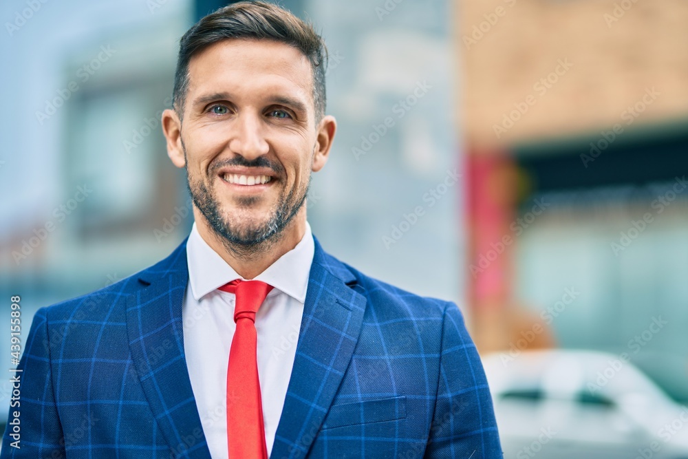 Fototapeta premium Young caucasian businessman smiling happy standing at the city.