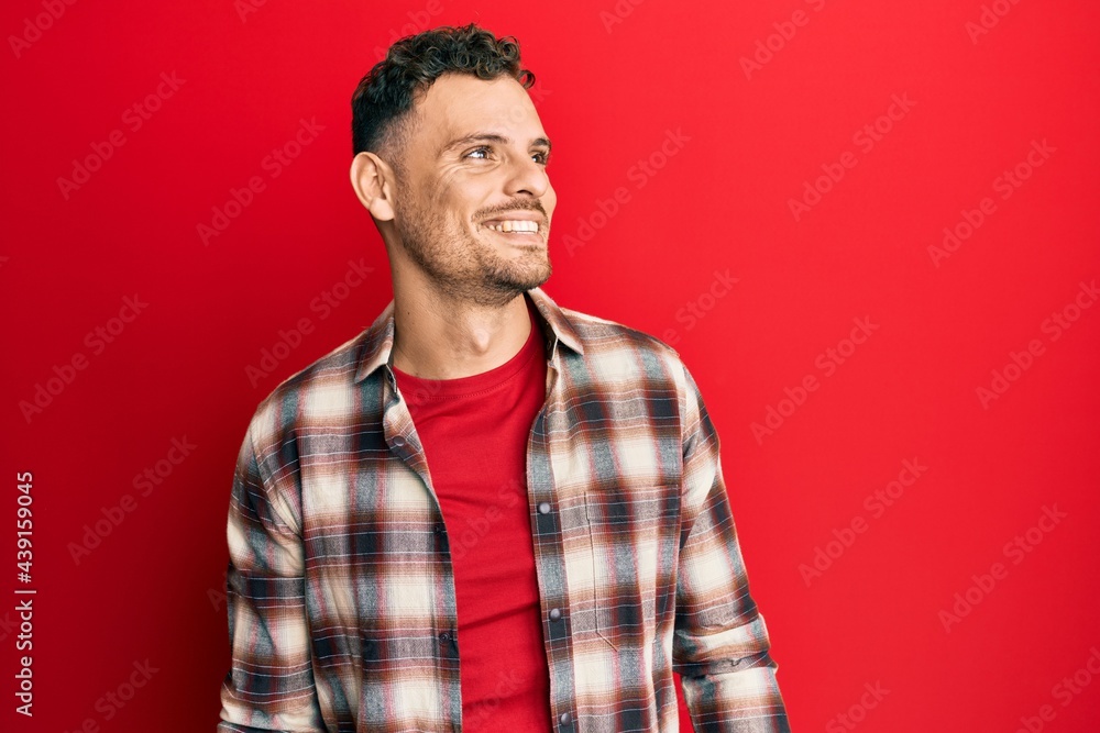 Young hispanic man wearing casual clothes looking to side, relax profile pose with natural face and confident smile. Young hispanic man wearing casual clothes looking to side, relax profile pose with natural face and confident smile.