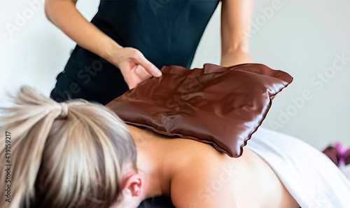 Fotografiet Fango massage is used to perform fango paraffin wraps