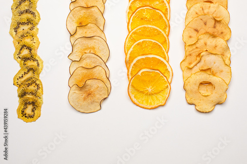 The dry pieces of different fruits in a row to fresh fruits photo