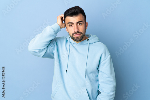 Caucasian man over isolated blue background with an expression of frustration and not understanding © luismolinero