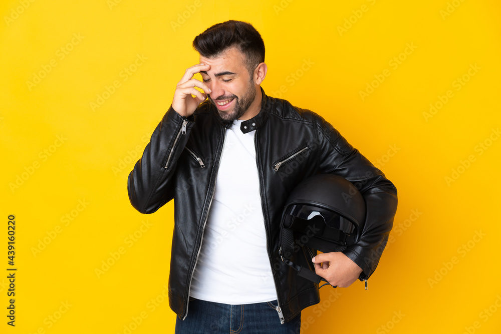 Caucasian man with a motorcycle helmet over isolated yellow background laughing Caucasian man with a motorcycle helmet over isolated yellow background laughing